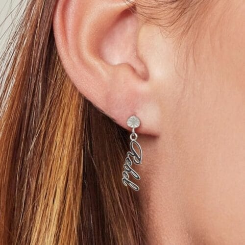 RVS-Oorbellen-Rebel-zilver-zilveren-dame-oorbellen-tekst-rebel-waterbestendige-trendy-oorbel-earrings-kopen-bestellen-model