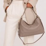 Leren Schoudertas Debbi donkertaupe leer schoudertassen flap gouden draaislot trendy suede dames tassen kopen bestellen model